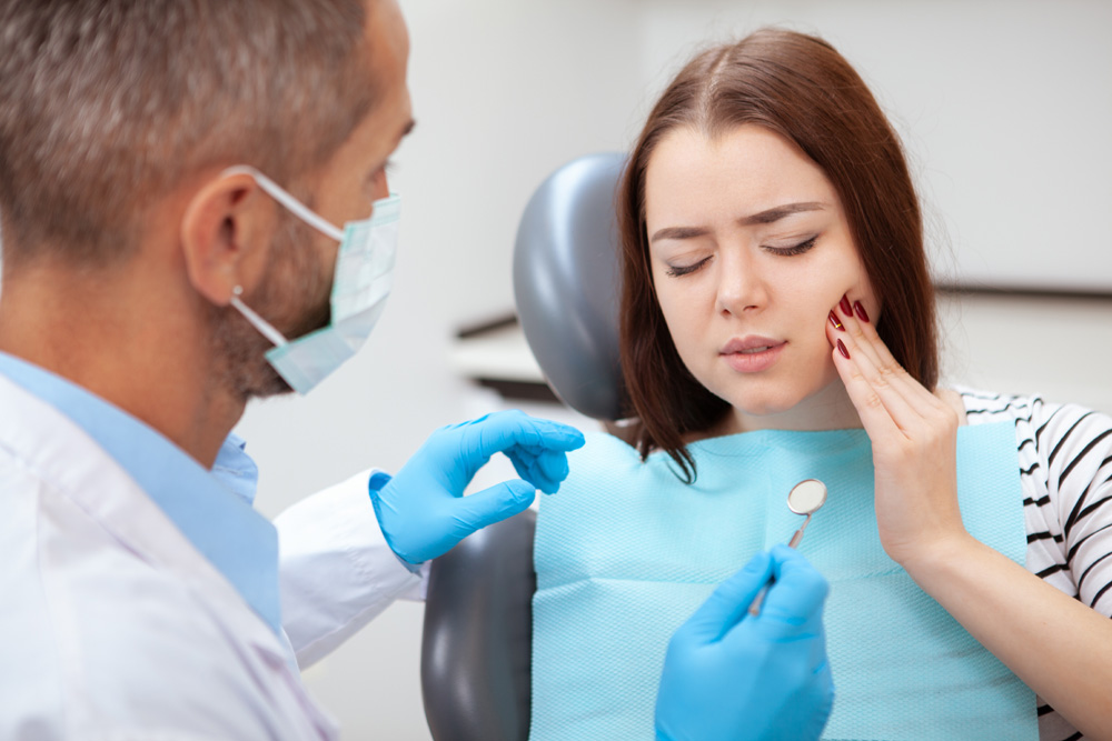 Female patient with terrible toothache visiting dentist